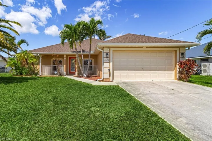 Ranch-style home featuring an attached garage, driveway, stucco siding, and a front lawn