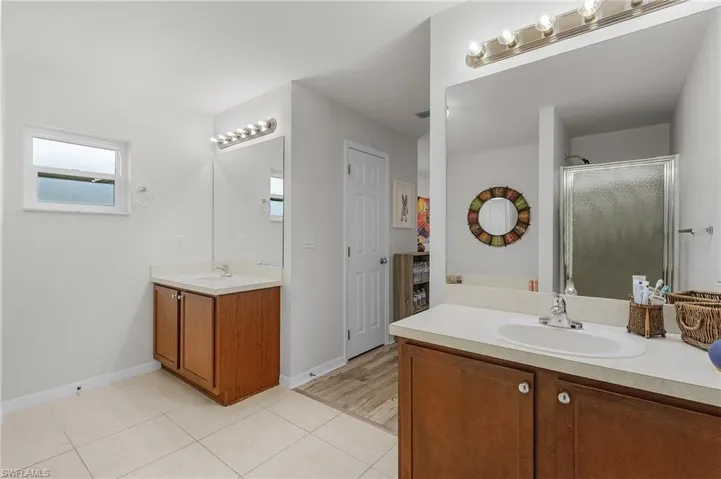 Master bathroom with a sink, baseboards, a shower stall, and tile patterned flooring