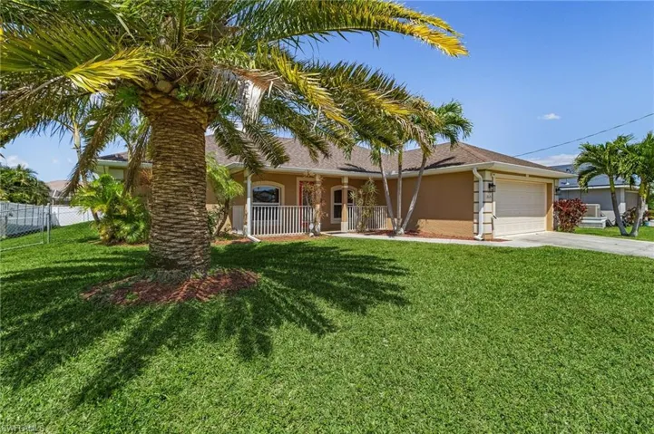View of front of home with driveway, fence, an attached garage, and a front lawn