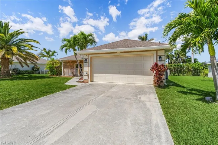 Single story home featuring a front yard, an attached garage, stucco siding, and concrete driveway