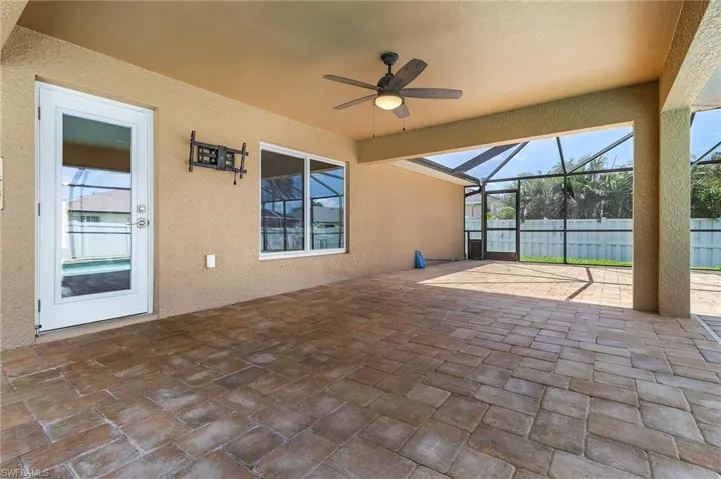 View of patio featuring fence, a lanai, and ceiling fan