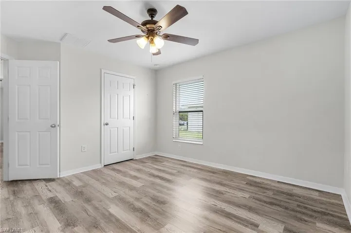 Unfurnished bedroom featuring baseboards, wood finished floors, and visible vents
