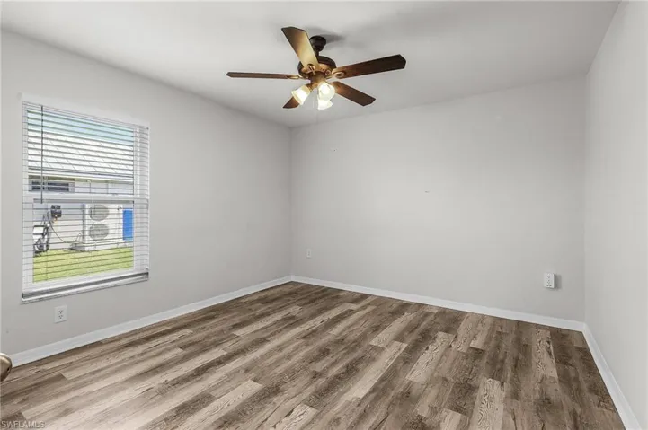 Spare room with baseboards, a ceiling fan, and wood finished floors