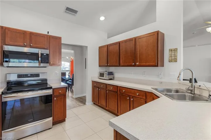 Kitchen with light countertops, a sink, visible vents, and stainless steel appliances