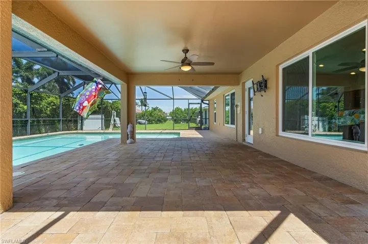 Pool featuring a lanai, a patio area, and a ceiling fan