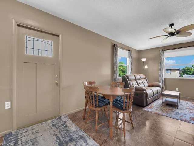 Dining room featuring a textured ceiling, a ceiling fan, and baseboards