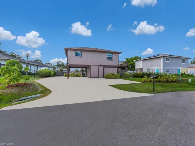 View of front of home with a front yard and driveway