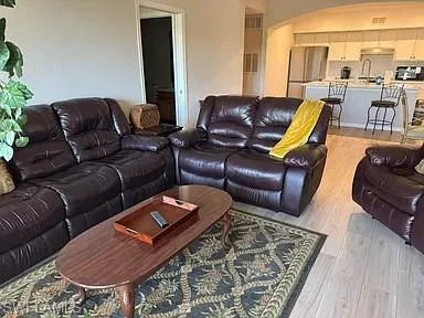 Living room with light wood-style flooring and arched walkways