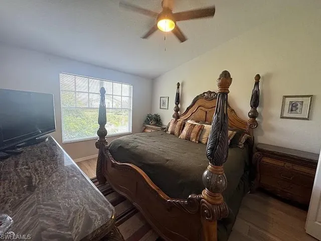Bedroom with wood finished floors, ceiling fan, and a textured ceiling