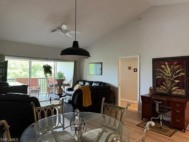 Dining room with wood finished floors, ceiling fan, and high vaulted ceiling