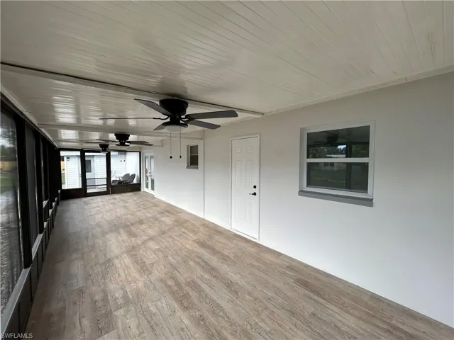 Unfurnished sunroom featuring ceiling fan and wood ceiling