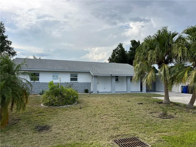 Ranch-style home featuring a front lawn