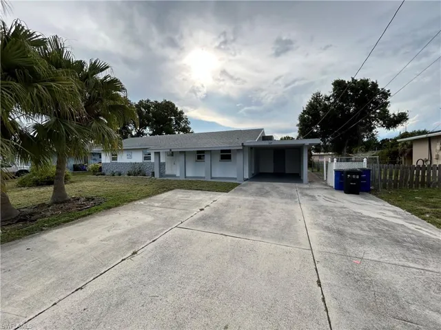 Ranch-style home with a front yard and a carport