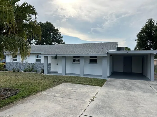 Ranch-style home with a front lawn and a carport