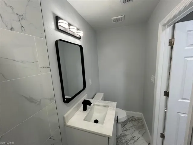 Bathroom featuring tile flooring, vanity, and toilet