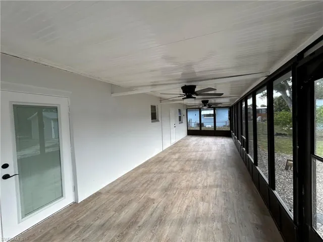 Unfurnished sunroom with ceiling fan