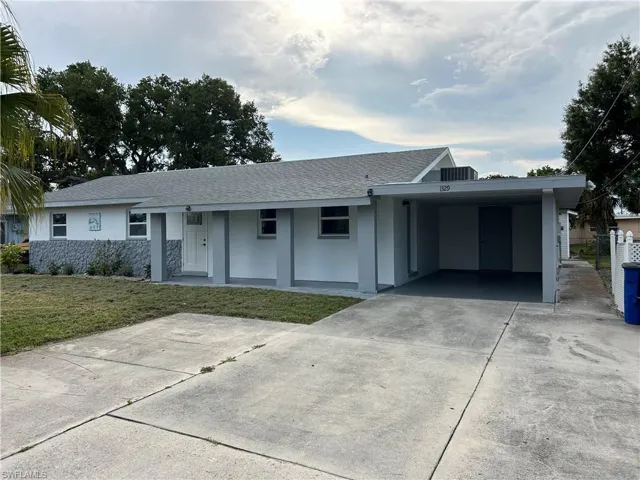 Ranch-style home with a carport and a front yard