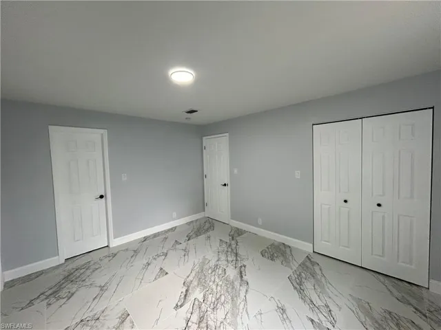 Unfurnished bedroom featuring a closet and light tile flooring