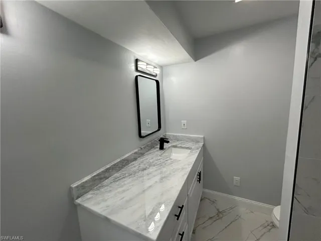 Bathroom with tile flooring, toilet, and large vanity