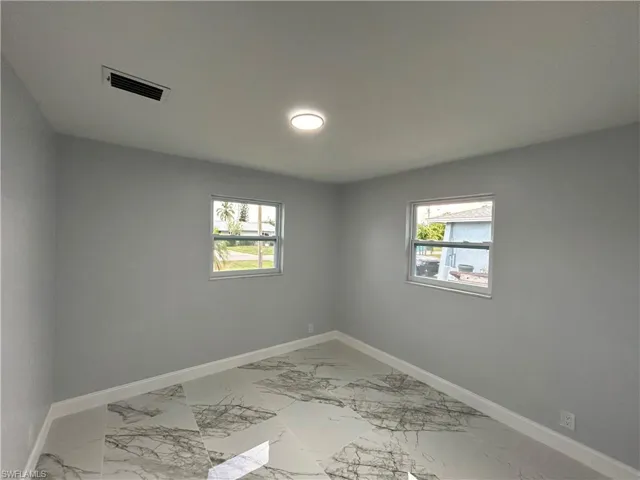 Unfurnished room featuring a wealth of natural light and light tile floors