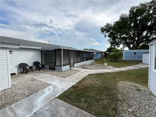 Back of property featuring a sunroom and a lawn