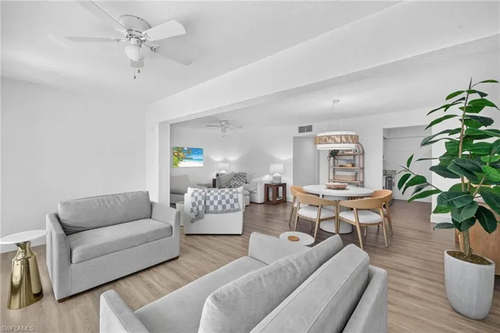 Bright living and dining areas featuring wood-finish flooring