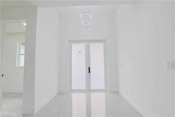Foyer featuring french doors and light tile patterned flooring