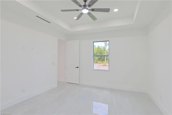 Unfurnished room featuring a tray ceiling, ceiling fan, and recessed lighting
