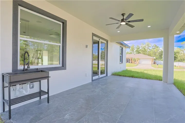 View of patio with a ceiling fan and a sink