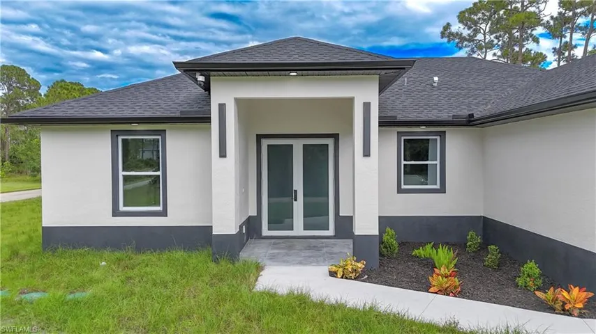 Entrance to property featuring french doors, roof with shingles, and stucco siding