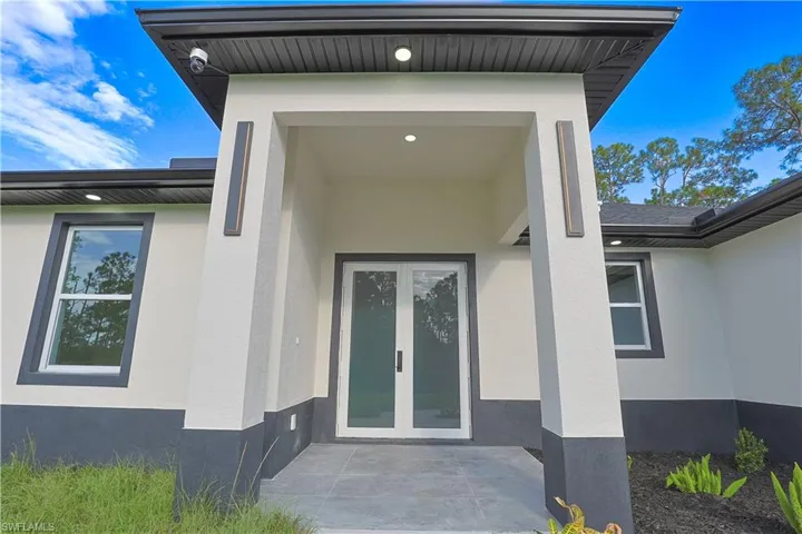 Property entrance featuring stucco siding and french doors