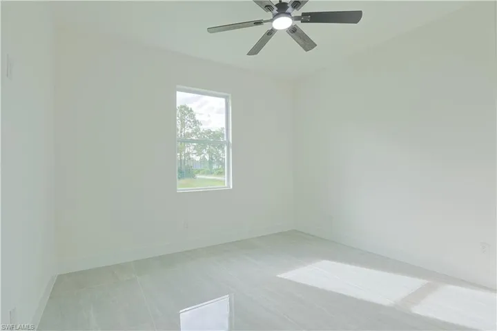 Unfurnished room featuring baseboards and a ceiling fan