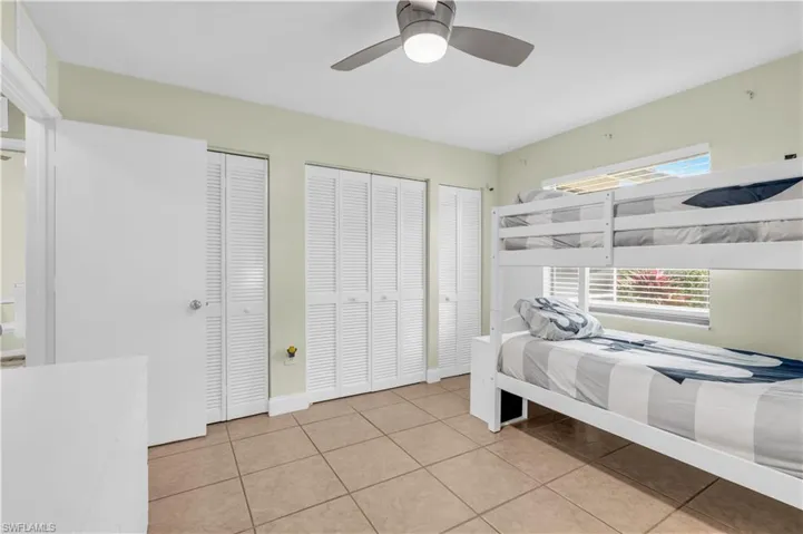 Unfurnished bedroom featuring two closets, ceiling fan, and light tile patterned floors