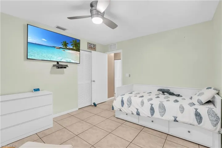 Bedroom with light tile patterned floors and ceiling fan
