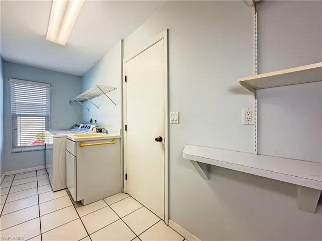 Washroom with light tile patterned floors and separate washer and dryer