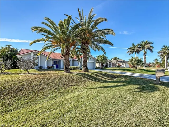View of front of property featuring stucco siding, a front lawn, a garage, and a residential view