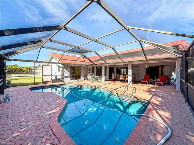 Swimming pool with a lanai, a sunroom, and a patio