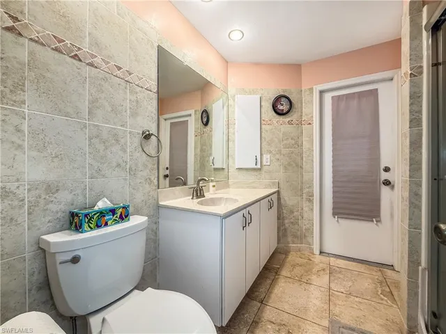 Bathroom featuring vanity and tile walls