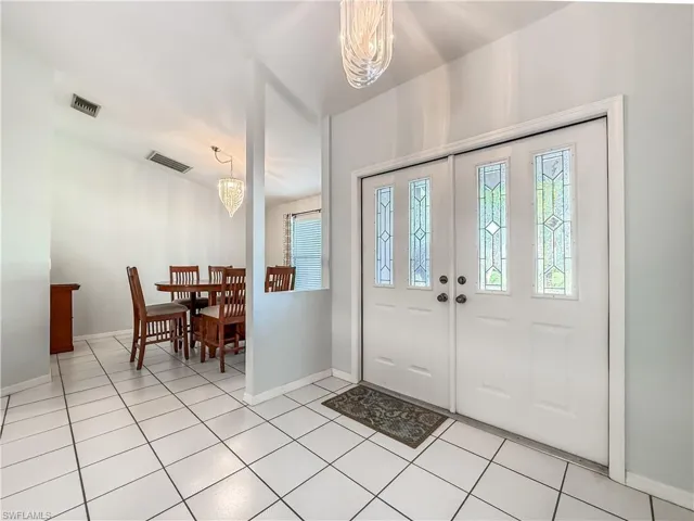 Entryway with a chandelier and light tile patterned floors