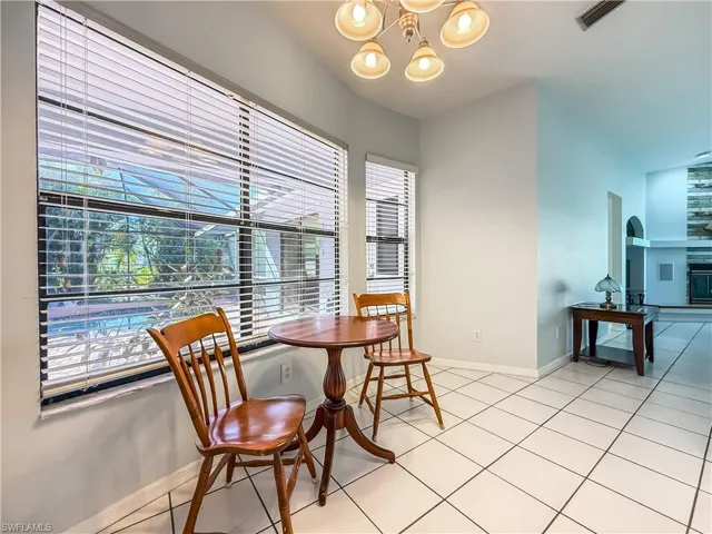 Dining area featuring plenty of natural light, light tile patterned flooring, and a chandelier