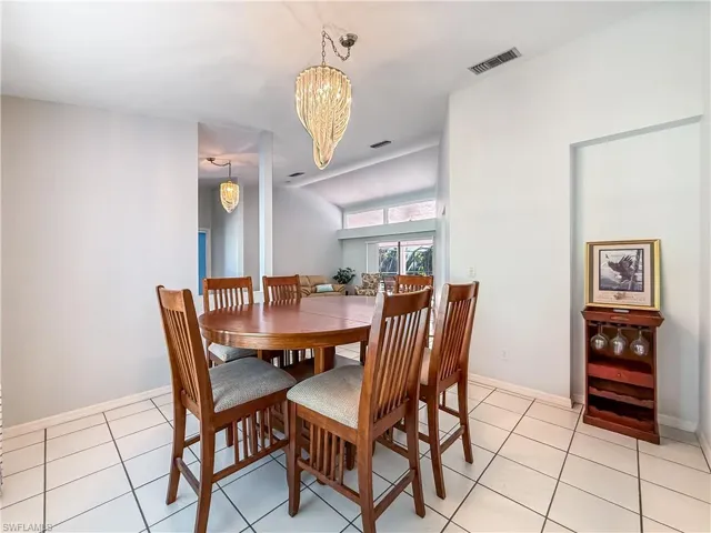 Dining space featuring light tile patterned flooring and a chandelier