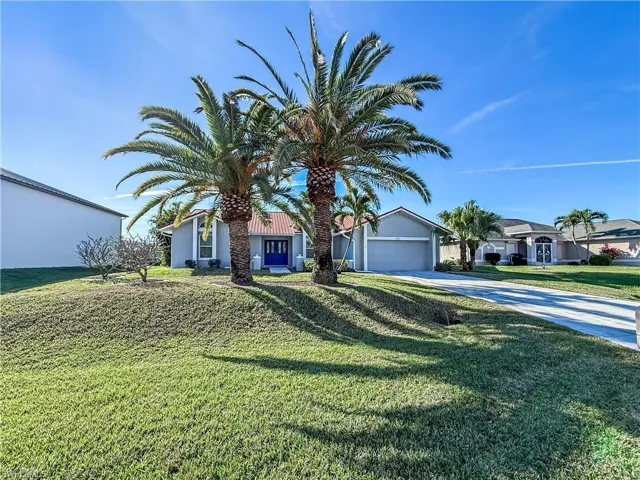 View of front of house featuring concrete driveway, a front yard, stucco siding, and a garage