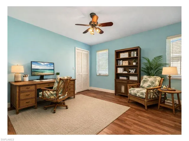 Staged Home office with dark wood-style floors, ceiling fan, and plenty of natural light