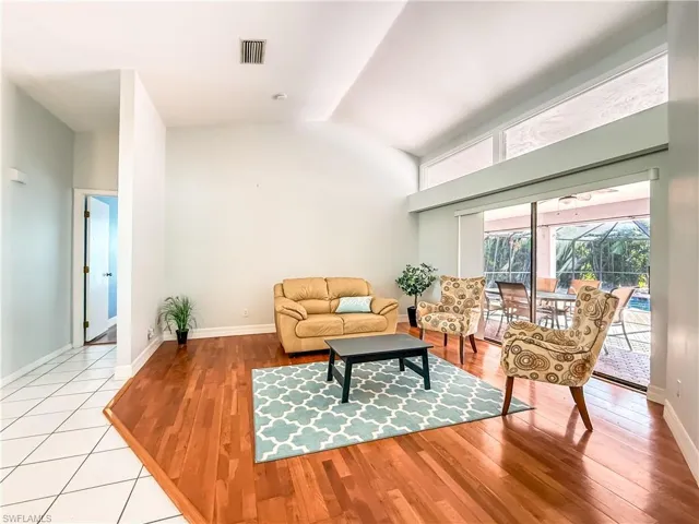 Living room with light wood-type flooring and vaulted ceiling