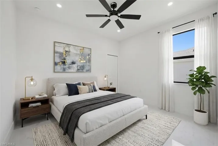 Spacious room featuring a large window with sheer drapes, recessed lighting, and a contemporary ceiling fan