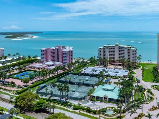 Expansive coastal property featuring multiple high-rise buildings, extensive tennis courts, and landscaped grounds
