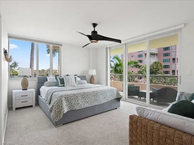 Carpeted interior space featuring a large window and sliding glass door to an exterior balcony