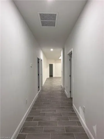 Hallway featuring baseboards and wood finish floors