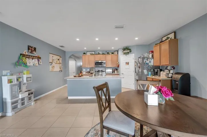 Kitchen featuring wood-finish cabinetry, stainless steel appliances, and a central island with a sink