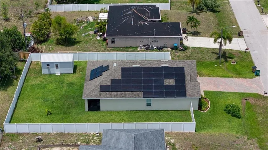 Single-story property with a light-colored exterior and dark-shingle roofing